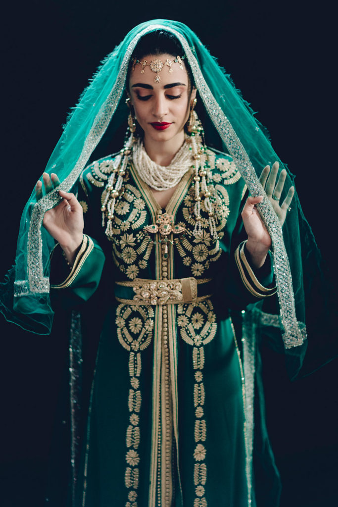 Bride in green and gold traditional gown with veil, representing global wedding traditions captured in luxury style